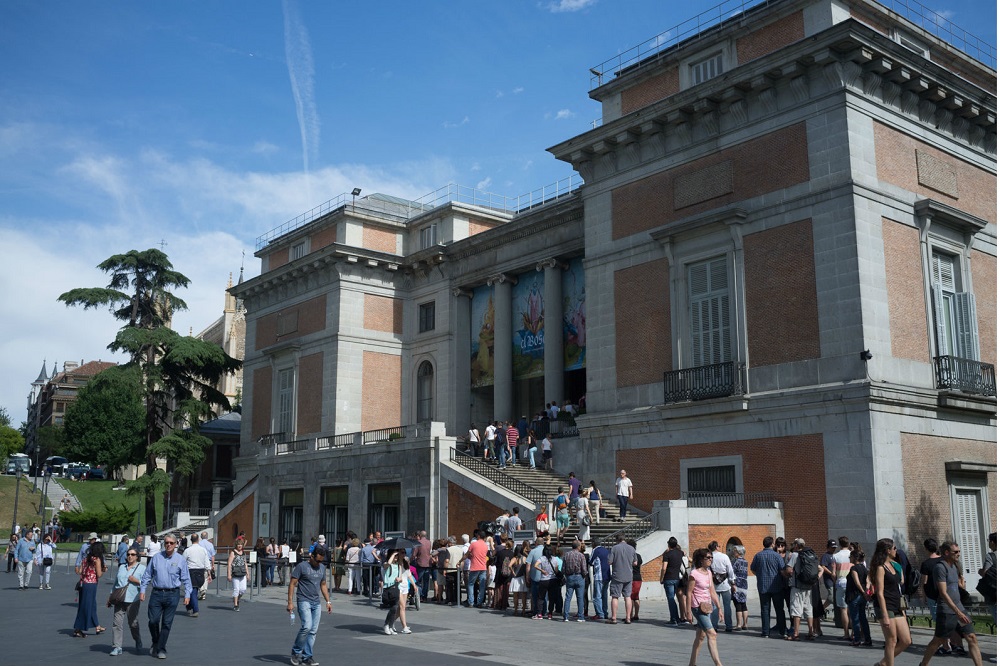 Bezoekers voor het Prado museum staan voor de ingang in de rij, te Madrid