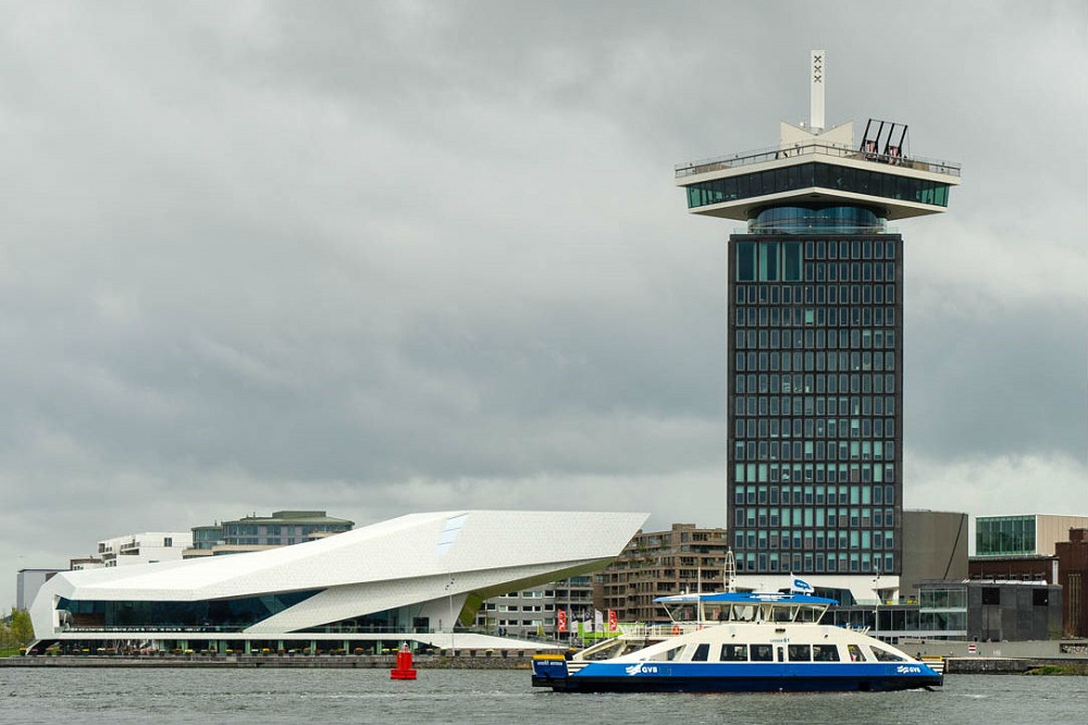 Een pont vaart voor het EYE en de A'DAM Toren te Amsterdam-Noord